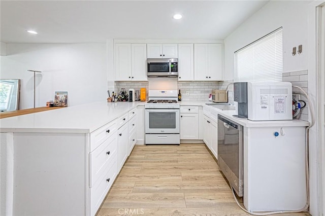 68 Timber Run Unit 45, Irvine, CA 92614 - kitchen with appliances with stainless steel finishes, a peninsula, light wood finished floors, healthy amount of natural light, and recessed lighting