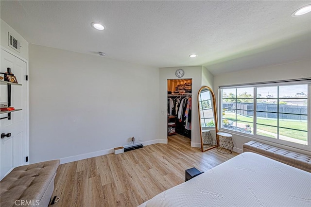 68 Timber Run Unit 45, Irvine, CA 92614 - bedroom with light wood finished floors, recessed lighting, a textured ceiling, and a walk in closet