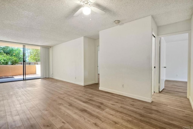 6180 Agee St Unit 159, University City, CA 92122 - empty room with a textured ceiling, wood finished floors, ceiling fan, expansive windows, and a smoke detector