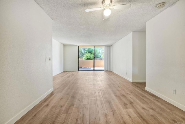 6180 Agee St Unit 159, University City, CA 92122 - spare room with a textured ceiling, ceiling fan, wood finished floors, a smoke detector, and a wall of windows