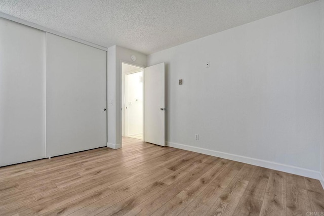 6180 Agee St Unit 159, University City, CA 92122 - unfurnished bedroom featuring light wood-type flooring, a textured ceiling, and a closet