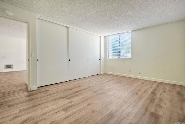 6180 Agee St Unit 159, University City, CA 92122 - unfurnished bedroom with a textured ceiling, wood finished floors, and a closet