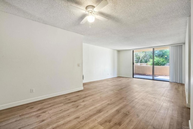 6180 Agee St Unit 159, University City, CA 92122 - empty room featuring a textured ceiling, a ceiling fan, a wall of windows, and light wood-style flooring