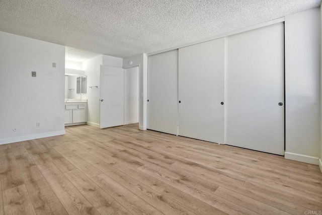 6180 Agee St Unit 159, University City, CA 92122 - unfurnished bedroom with light wood-style flooring, a textured ceiling, and connected bathroom