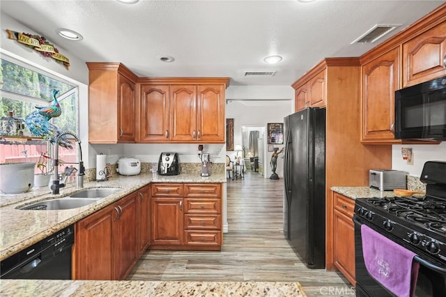 44505 Shadowcrest Dr, Lancaster, CA 93536 - kitchen with black appliances, light stone counters, light wood-style flooring, brown cabinetry, and recessed lighting