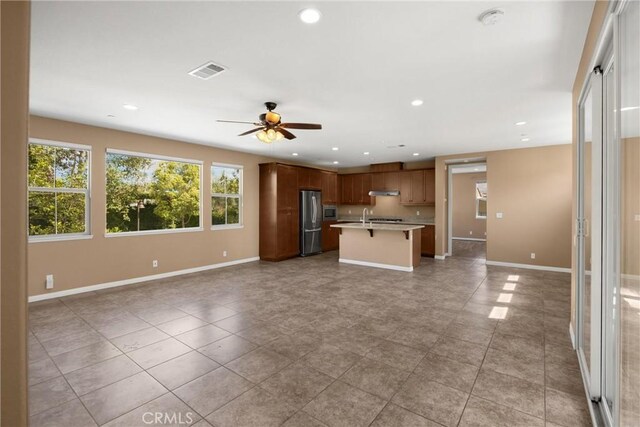 403 Sevilla Dr, Brea, CA 92823 - kitchen with open floor plan, freestanding refrigerator, light countertops, ceiling fan, and a center island with sink