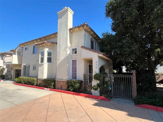 259 S California St, San Gabriel, CA 91776 - view of property exterior with a chimney, a tile roof, stucco siding, and a gate
