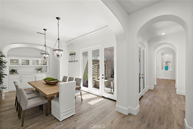 19 Dennis Ln, Ladera Ranch, CA 92694 - dining space with french doors, ornamental molding, light wood finished floors, arched walkways, and recessed lighting