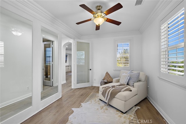 19 Dennis Ln, Ladera Ranch, CA 92694 - living area featuring arched walkways, wood finished floors, french doors, a ceiling fan, and crown molding