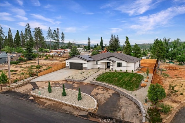 6638 Dolores Dr, Paradise, CA 95969 - view of front of home featuring concrete driveway, an attached garage, and solar panels