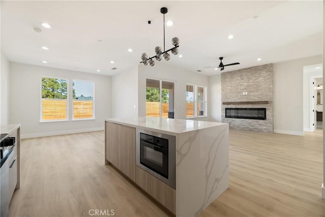6638 Dolores Dr, Paradise, CA 95969 - kitchen featuring modern cabinets, a ceiling fan, open floor plan, a fireplace, and recessed lighting
