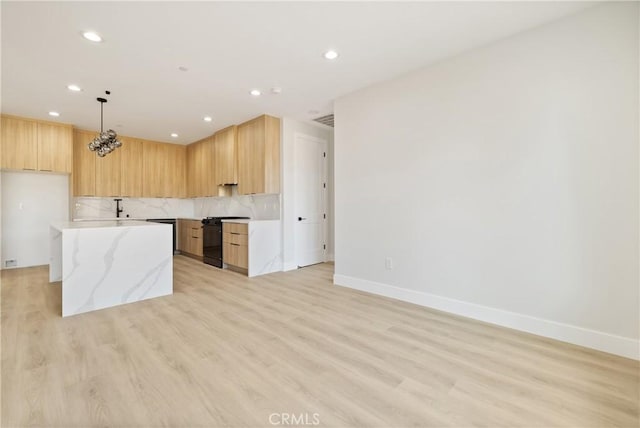 6638 Dolores Dr, Paradise, CA 95969 - kitchen featuring black range with gas stovetop, recessed lighting, backsplash, light wood-style floors, and light stone countertops