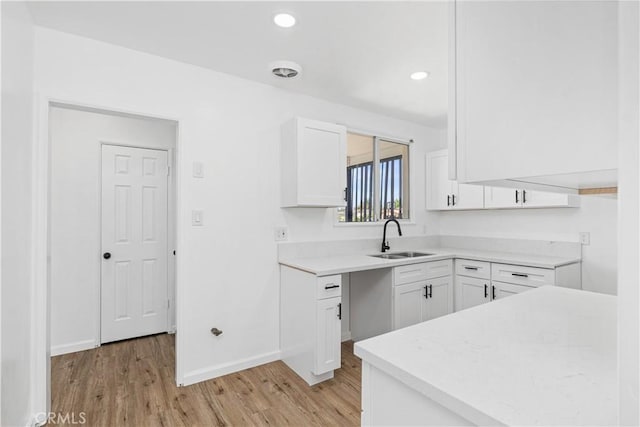 1920 Doolittle Ave, Bakersfield, CA 93304 - kitchen featuring light wood finished floors, light countertops, white cabinetry, and recessed lighting