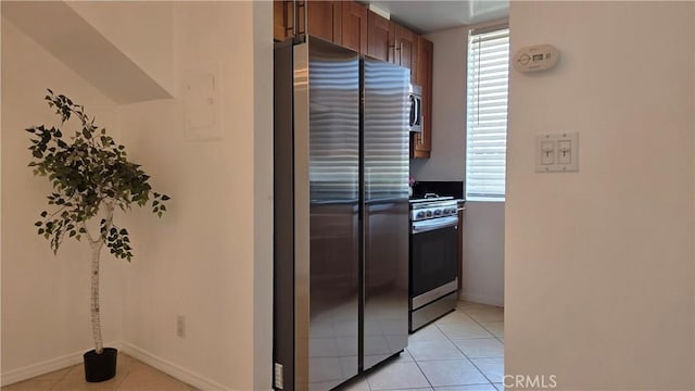 856 N Van Ness Ave Unit 3, Los Angeles, CA 90038 - kitchen with appliances with stainless steel finishes, light tile patterned floors, and brown cabinets