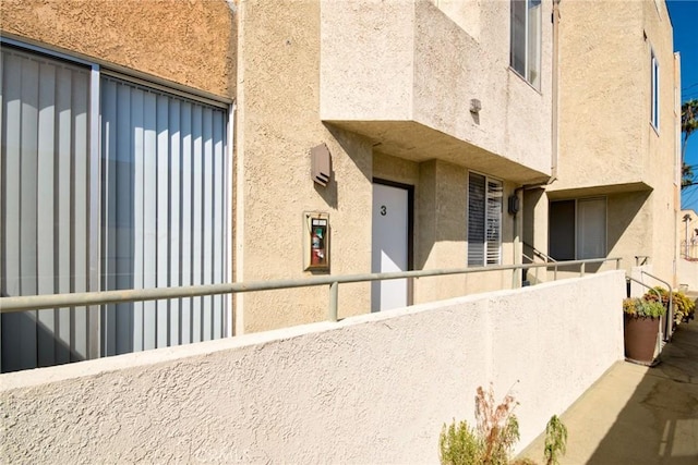 856 N Van Ness Ave Unit 3, Los Angeles, CA 90038 - view of exterior entry with stucco siding, a balcony, and board and batten siding