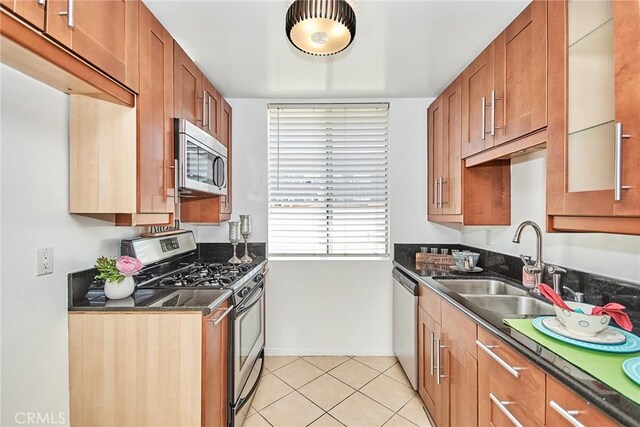 856 N Van Ness Ave Unit 3, Los Angeles, CA 90038 - kitchen featuring appliances with stainless steel finishes, dark countertops, brown cabinetry, and light tile patterned flooring