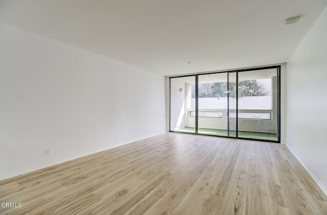 121 S Hope St Unit 321, Los Angeles, CA 90012 - unfurnished room featuring light wood-type flooring and expansive windows