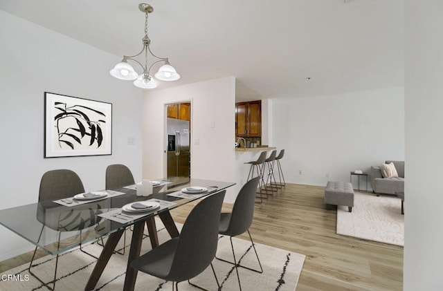 121 S Hope St Unit 321, Los Angeles, CA 90012 - dining room featuring light wood finished floors and a chandelier