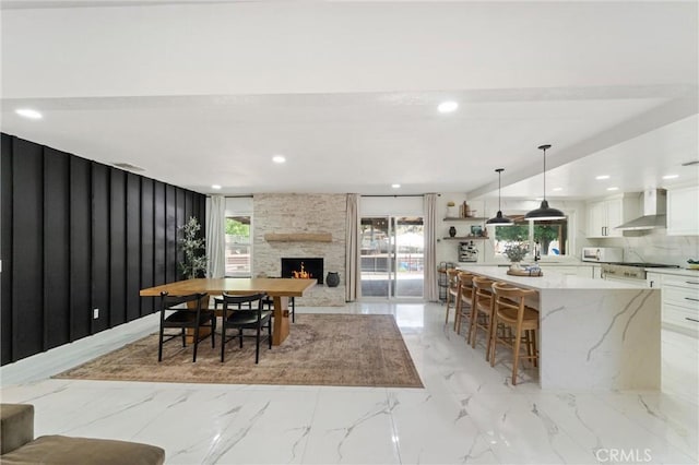 8873 Reche Canyon Rd, Colton, CA 92324 - dining space featuring light marble finish floors, plenty of natural light, a fireplace, and recessed lighting