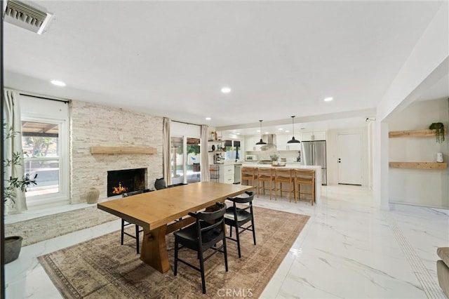 8873 Reche Canyon Rd, Colton, CA 92324 - dining room with a stone fireplace, light marble finish floors, plenty of natural light, and recessed lighting