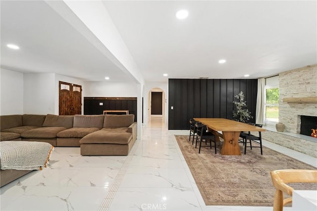 8873 Reche Canyon Rd, Colton, CA 92324 - living room featuring arched walkways, recessed lighting, marble tiled flooring, and a fireplace