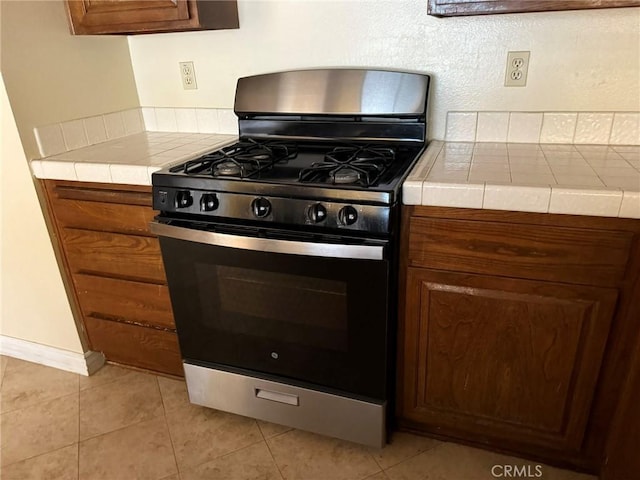 640 Juniper Way, La Habra, CA 90631 - kitchen with black range with gas stovetop, tile countertops, light tile patterned flooring, and brown cabinetry