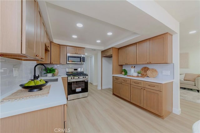 1615 Via Linda Unit 16, Fullerton, CA 92833 - kitchen with appliances with stainless steel finishes, light wood-style flooring, light countertops, tasteful backsplash, and a raised ceiling