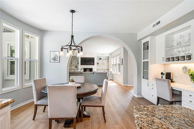 3417 Kildare Ct, Burbank, CA 91504 - dining space featuring arched walkways, light wood-style flooring, built in features, and built in study area