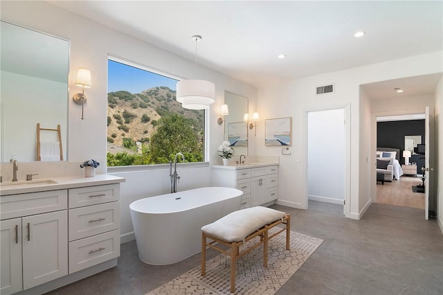 3417 Kildare Ct, Burbank, CA 91504 - full bathroom with two vanities, a freestanding bath, recessed lighting, a mountain view, and finished concrete floors