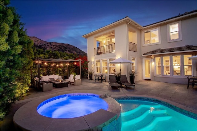 3417 Kildare Ct, Burbank, CA 91504 - rear view of house featuring a balcony, an outdoor living space with a fire pit, a mountain view, a patio area, and stucco siding
