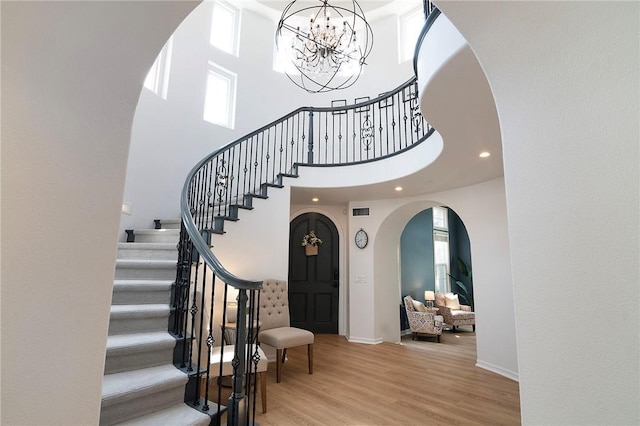 3417 Kildare Ct, Burbank, CA 91504 - foyer with arched walkways, stairs, a chandelier, wood finished floors, and a high ceiling