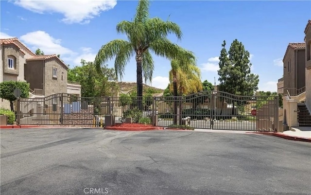 1025 La Terraza Cir Unit 204, Corona, CA 92879 - view of asphalt street featuring a gate, a gated entry, and curbs