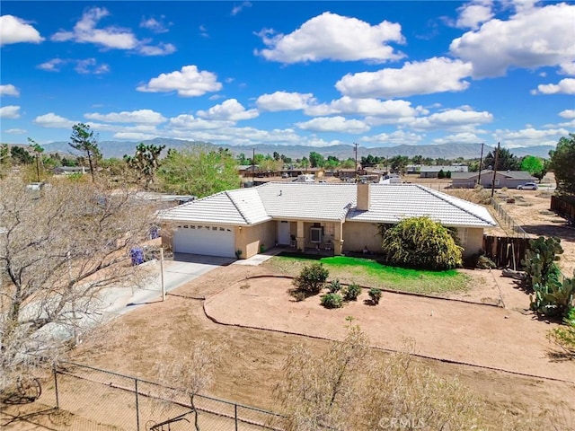 21919 Standing Rock Ave, Apple Valley, CA 92307 - ranch-style house featuring a tiled roof, driveway, a garage, stucco siding, and a mountain view