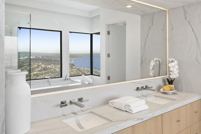 2082 Via Casa Alta, La Jolla, CA 92037 - bathroom featuring double vanity, plenty of natural light, a tub with marble appearance, and a water view