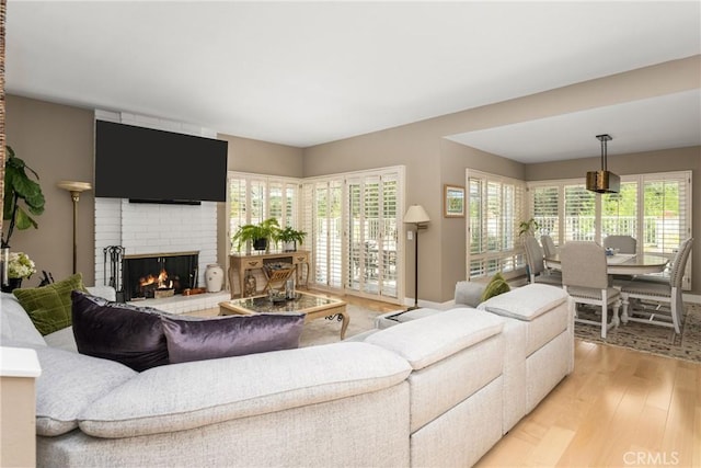 8009 E Eucalyptus Trl, Orange, CA 92869 - living area with a brick fireplace, light wood-style floors, and healthy amount of natural light