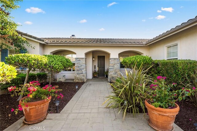 1708 Victoria Way, San Marcos, CA 92069 - doorway to property featuring stucco siding, a tile roof, stone siding, and a chimney