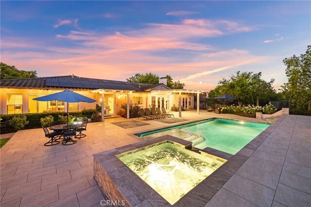 1708 Victoria Way, San Marcos, CA 92069 - pool at dusk featuring french doors, a patio area, a pergola, and a pool with connected hot tub