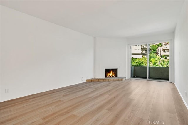 3480 Barham Blvd Unit 215, Los Angeles, CA 90068 - unfurnished living room with light wood-style flooring and a fireplace