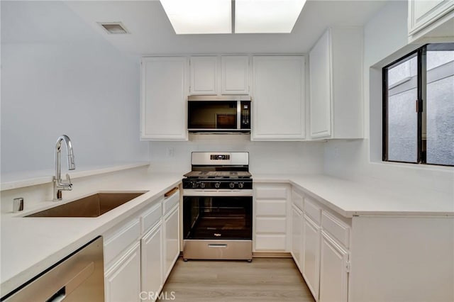 3480 Barham Blvd Unit 215, Los Angeles, CA 90068 - kitchen featuring stainless steel appliances, white cabinets, light wood-type flooring, and light countertops