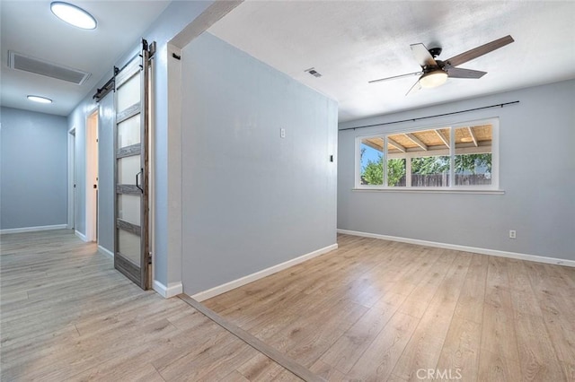 3318 Stanford Ave, Clovis, CA 93611 - empty room with a barn door, wood finished floors, and ceiling fan