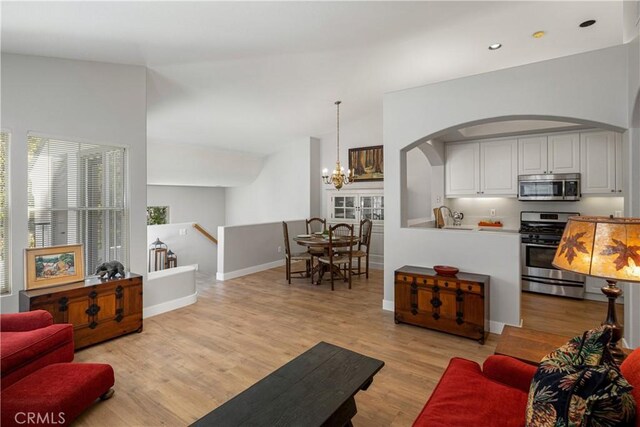 8 Diamant Way, Aliso Viejo, CA 92656 - living room with arched walkways, a chandelier, light wood finished floors, and recessed lighting