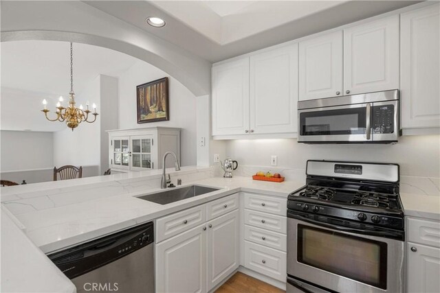 8 Diamant Way, Aliso Viejo, CA 92656 - kitchen with stainless steel appliances, a chandelier, recessed lighting, white cabinets, and light stone counters