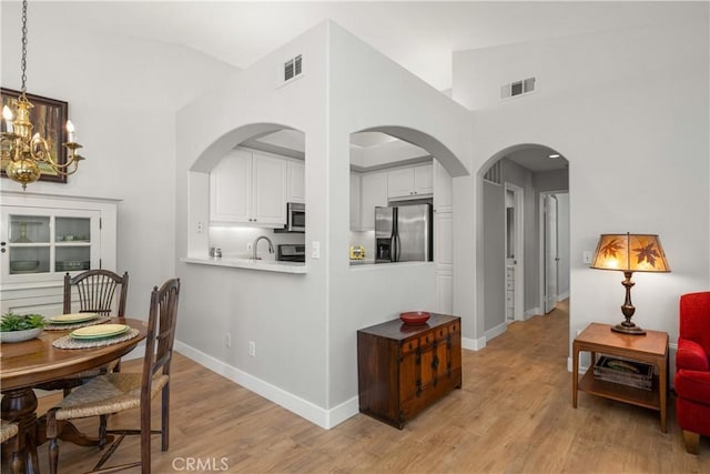 8 Diamant Way, Aliso Viejo, CA 92656 - dining room featuring light wood-style flooring, a chandelier, and vaulted ceiling