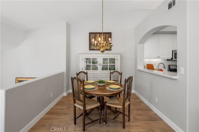 8 Diamant Way, Aliso Viejo, CA 92656 - dining space featuring a chandelier, arched walkways, and wood finished floors