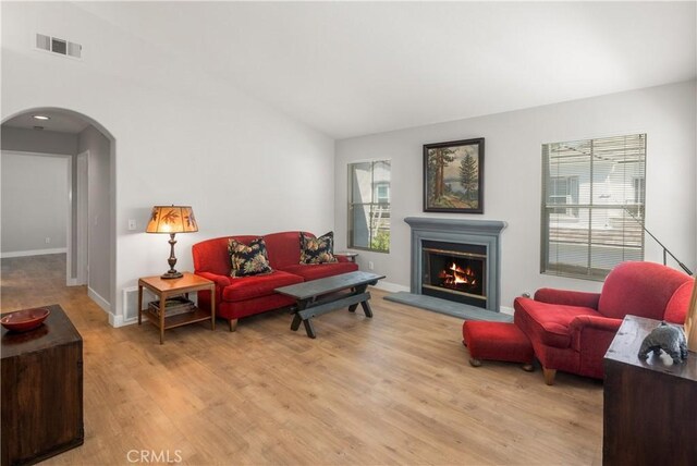 8 Diamant Way, Aliso Viejo, CA 92656 - living room with arched walkways, light wood-style floors, lofted ceiling, and a lit fireplace
