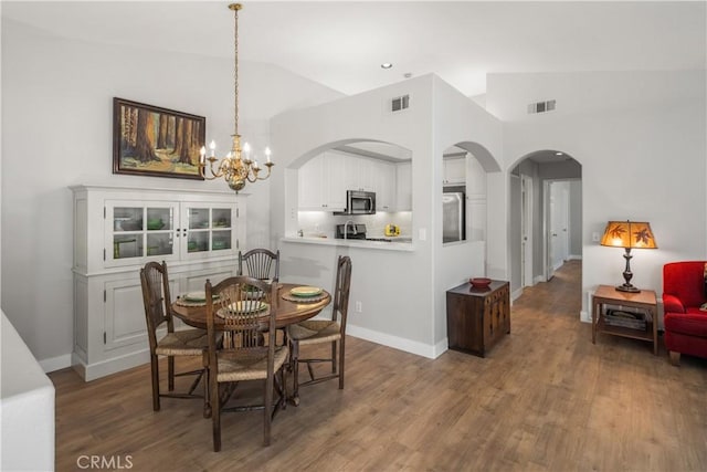 8 Diamant Way, Aliso Viejo, CA 92656 - dining room featuring a chandelier, arched walkways, wood finished floors, lofted ceiling, and recessed lighting