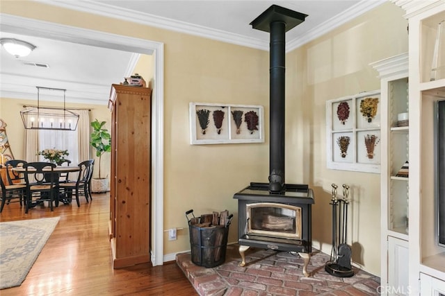 4328 Sunset Ave, Montrose, CA 91020 - detailed view of crown molding, a wood stove, a chandelier, and wood finished floors