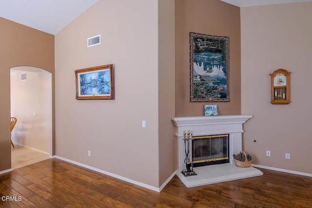 20325 Tamara Pl, Santa Clarita, CA 91350 - unfurnished living room with arched walkways, wood finished floors, a tile fireplace, and a towering ceiling