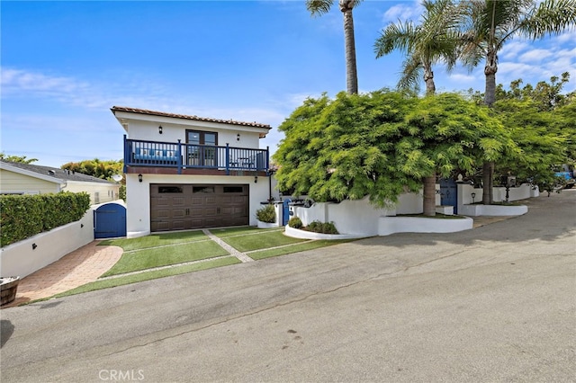 490 Agate, Laguna Beach, CA 92651 - mediterranean / spanish-style home with a gate, stucco siding, concrete driveway, a balcony, and a garage