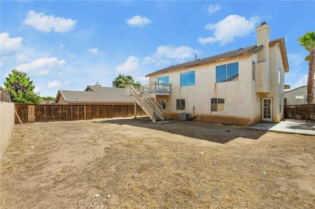 9304 Palo Verde Dr, Hesperia, CA 92344 - rear view of house with stairway, a fenced backyard, a chimney, a wooden deck, and stucco siding
